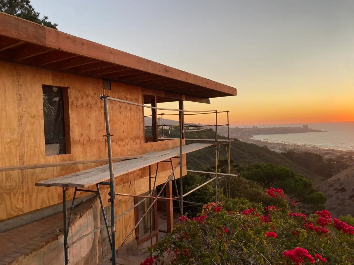 Hillside La Jolla home under construction at golden hour above the canyon