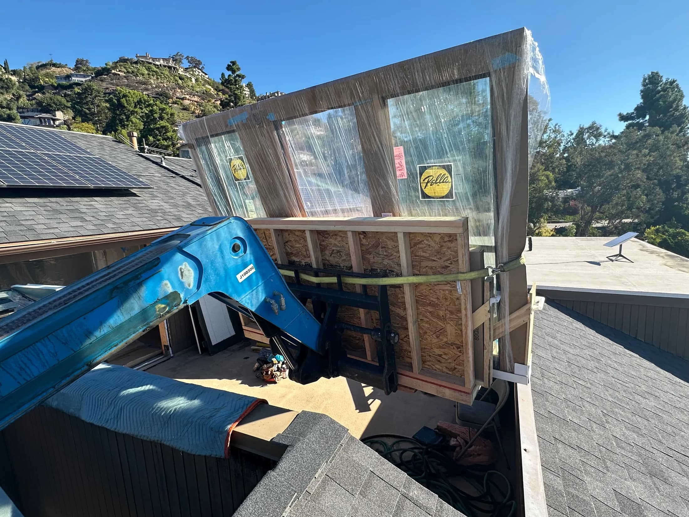 The crated slider set down at roof level, still strapped to the forks.