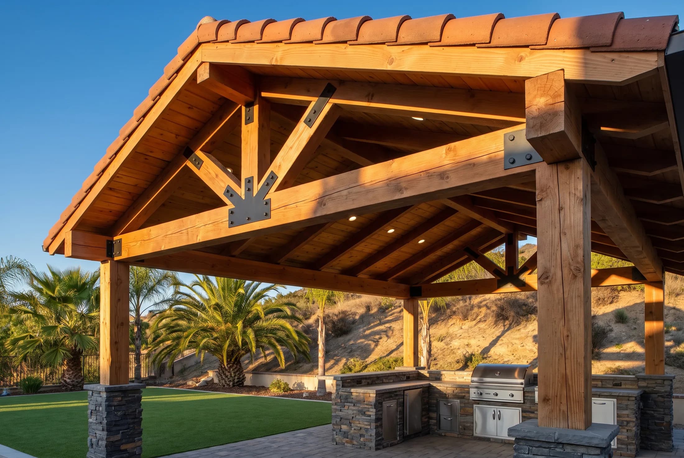 Custom cedar pavilion with exposed king-post trusses, blackened steel brackets, and a tongue-and-groove ceiling