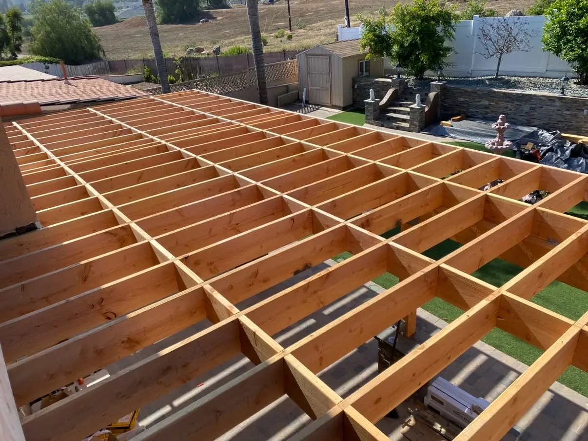 Finished covered patio and deck with stone columns behind a Rancho San Diego home