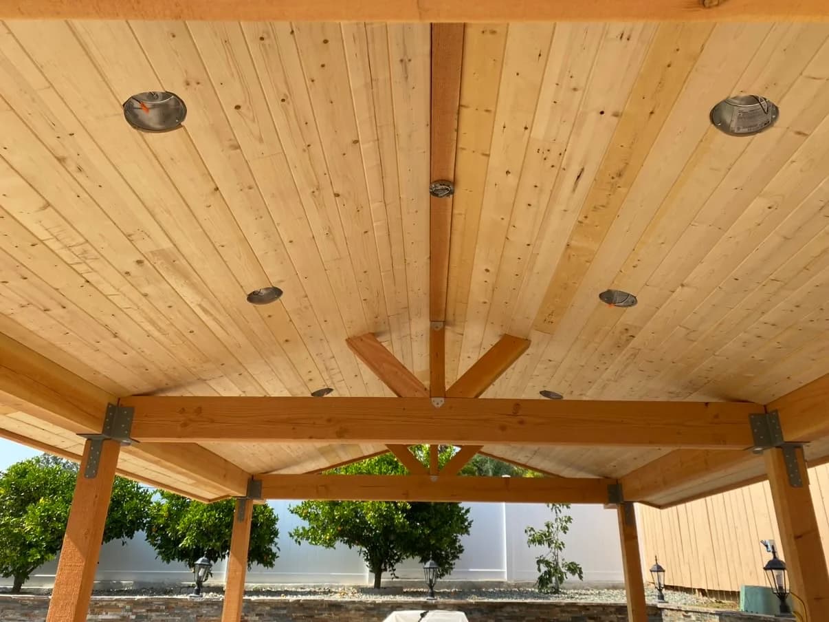 Cedar truss and tongue-and-groove ceiling detail seen from underneath a finished pavilion