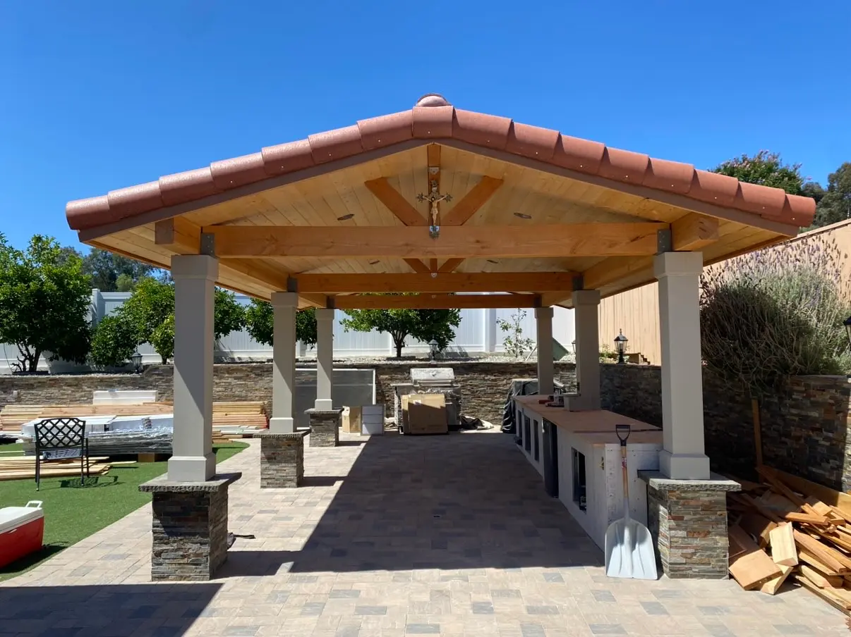 The terracotta barrel tile roof and rounded ridge cap on, with the columns wrapped in plaster and the counter run in place down the right side.