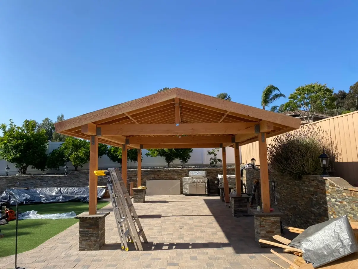 Finished cedar pavilion with a tile roof and stone-clad columns in Rancho San Diego, California