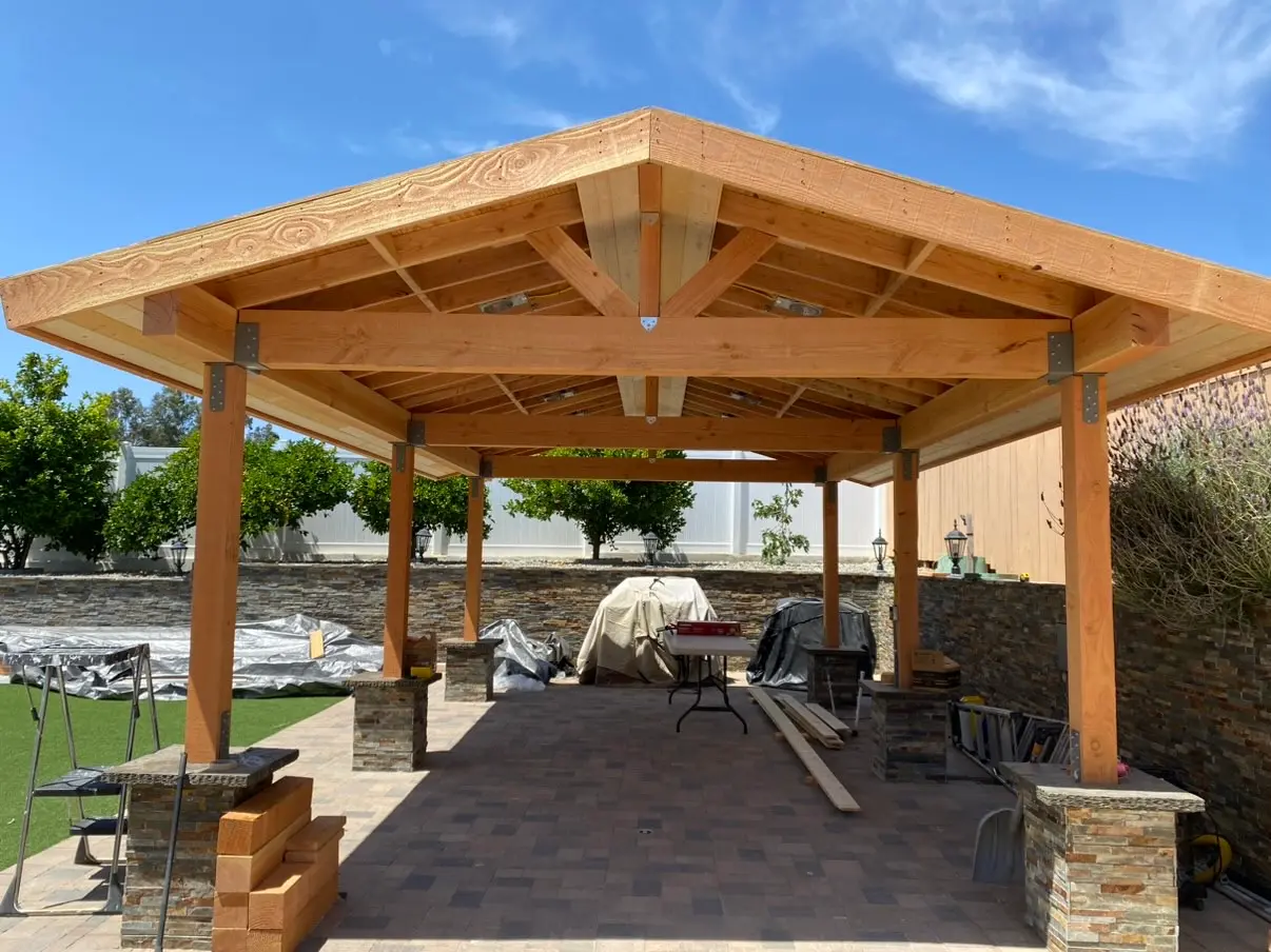 Stone-clad outdoor kitchen counter running the length of a covered pavilion